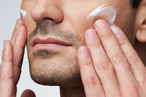 Man applying face cream to cheeks as part of a daily skincare routine